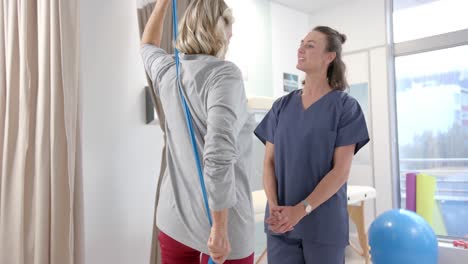 caucasian female physiotherapist and female senior patient with prosthetic leg exercising