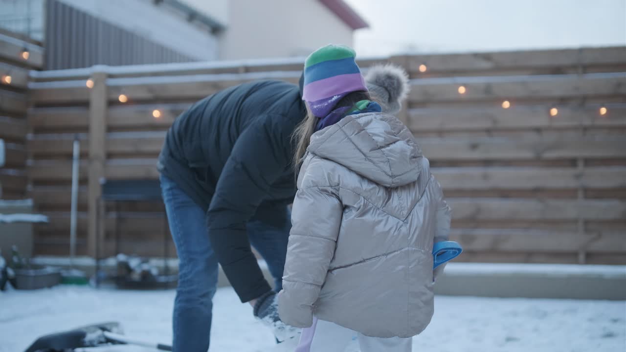 дедушка и внучка веселятся в снегу.