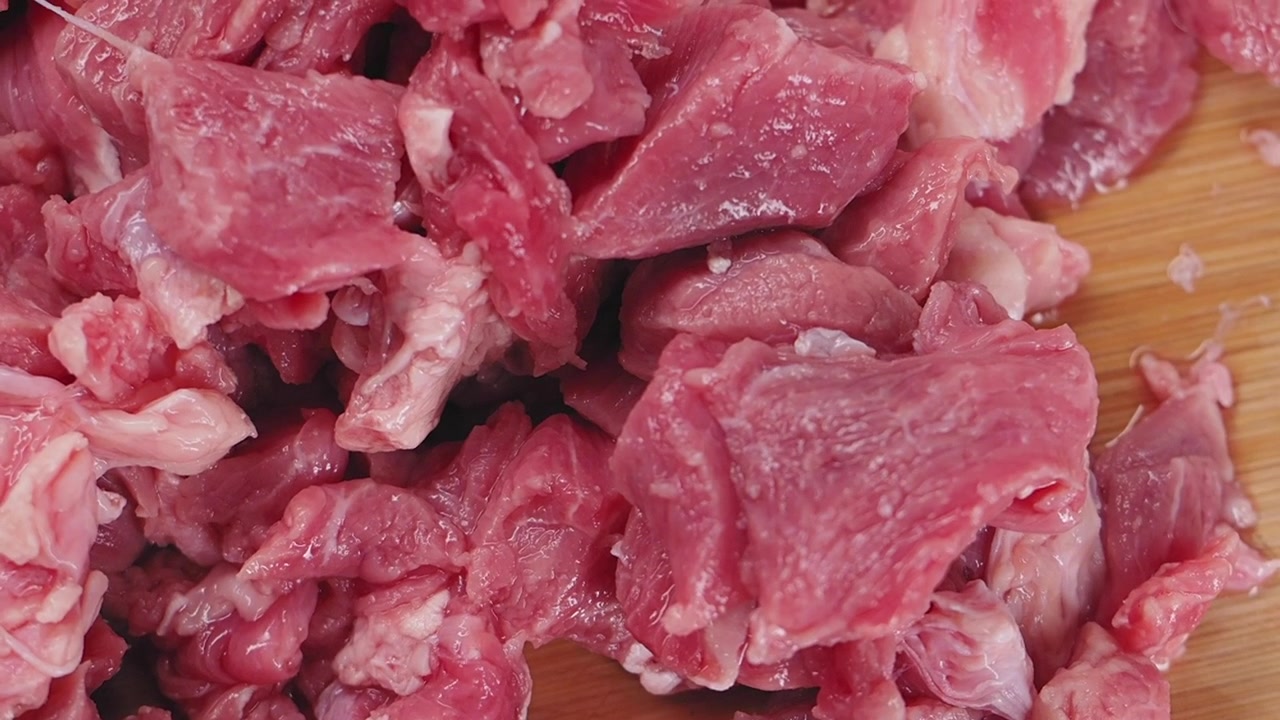 Daging Sapi Mentah Segar Potong Dadu di atas Talenan Kayu