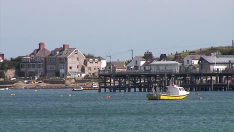 a white and yellow boat moored in front of a victorian pier at the dorset town of swanage in the united kingdom