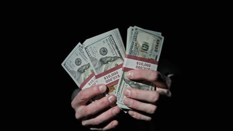 three stacks of 10000 american dollars bundles in male hands on black background