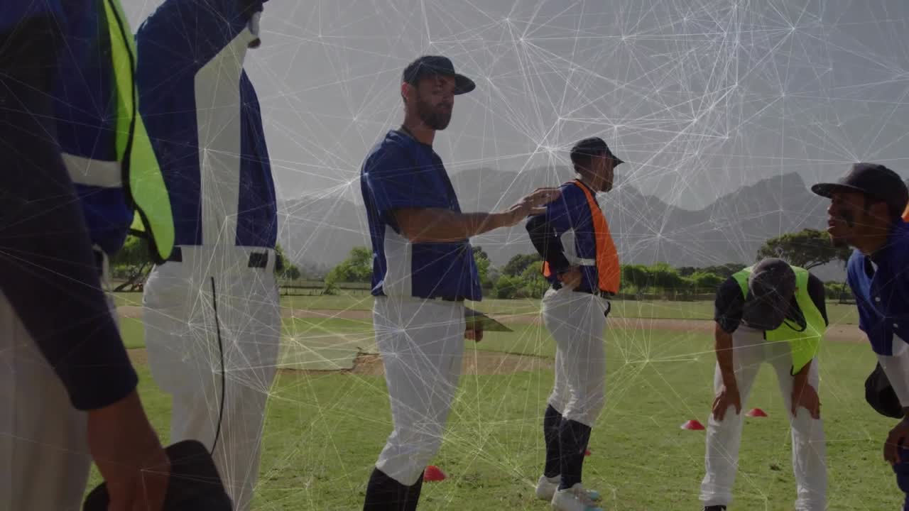 野球の練習で、コーチが内野の選手に手を添えてスタンスを修正指導している様子。