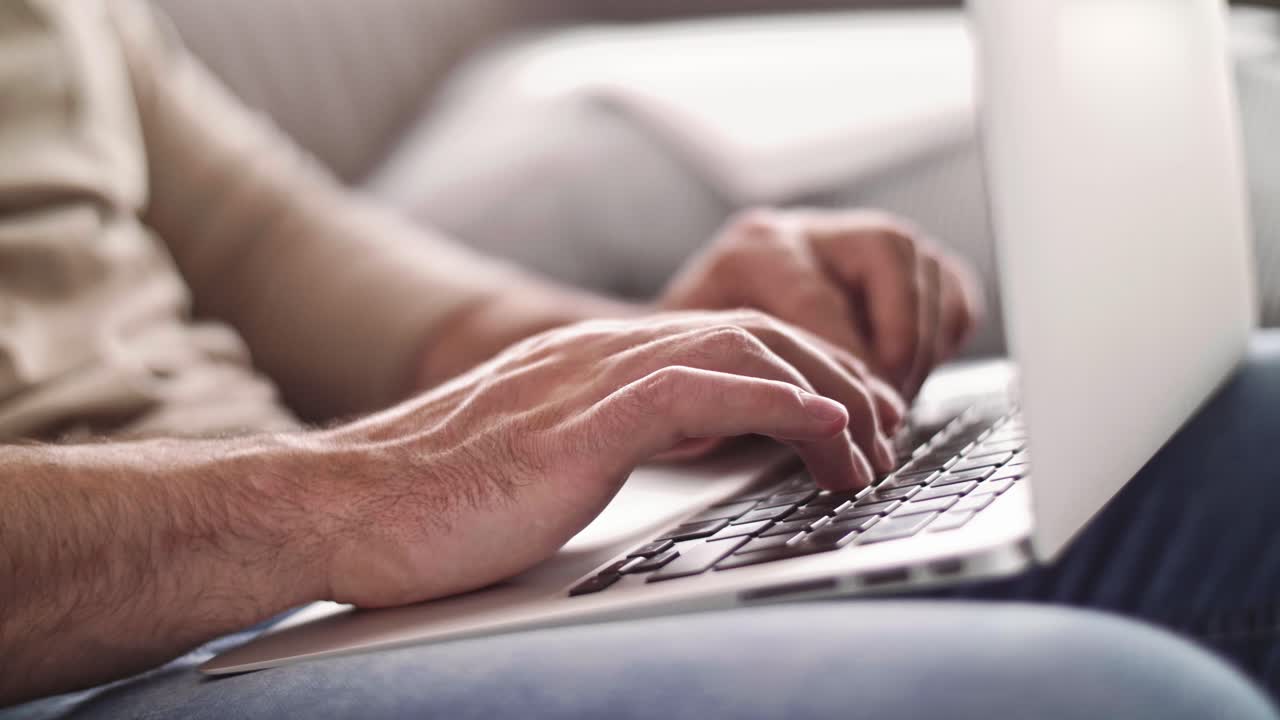 Man's hand typing on laptop at home office