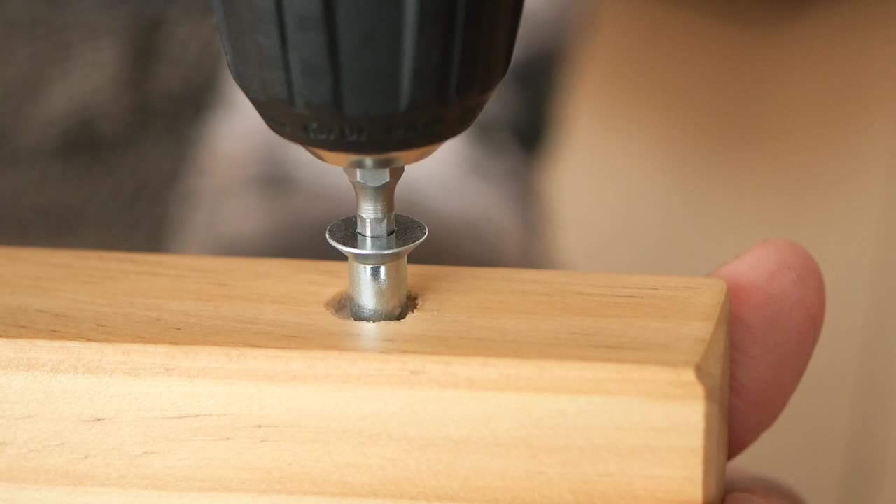 Drilling a screw into a wooden plank