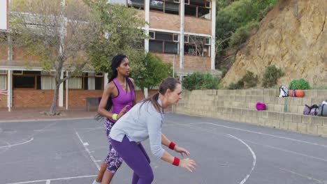 diverse female basketball team playing match, dribbling and shooting ball