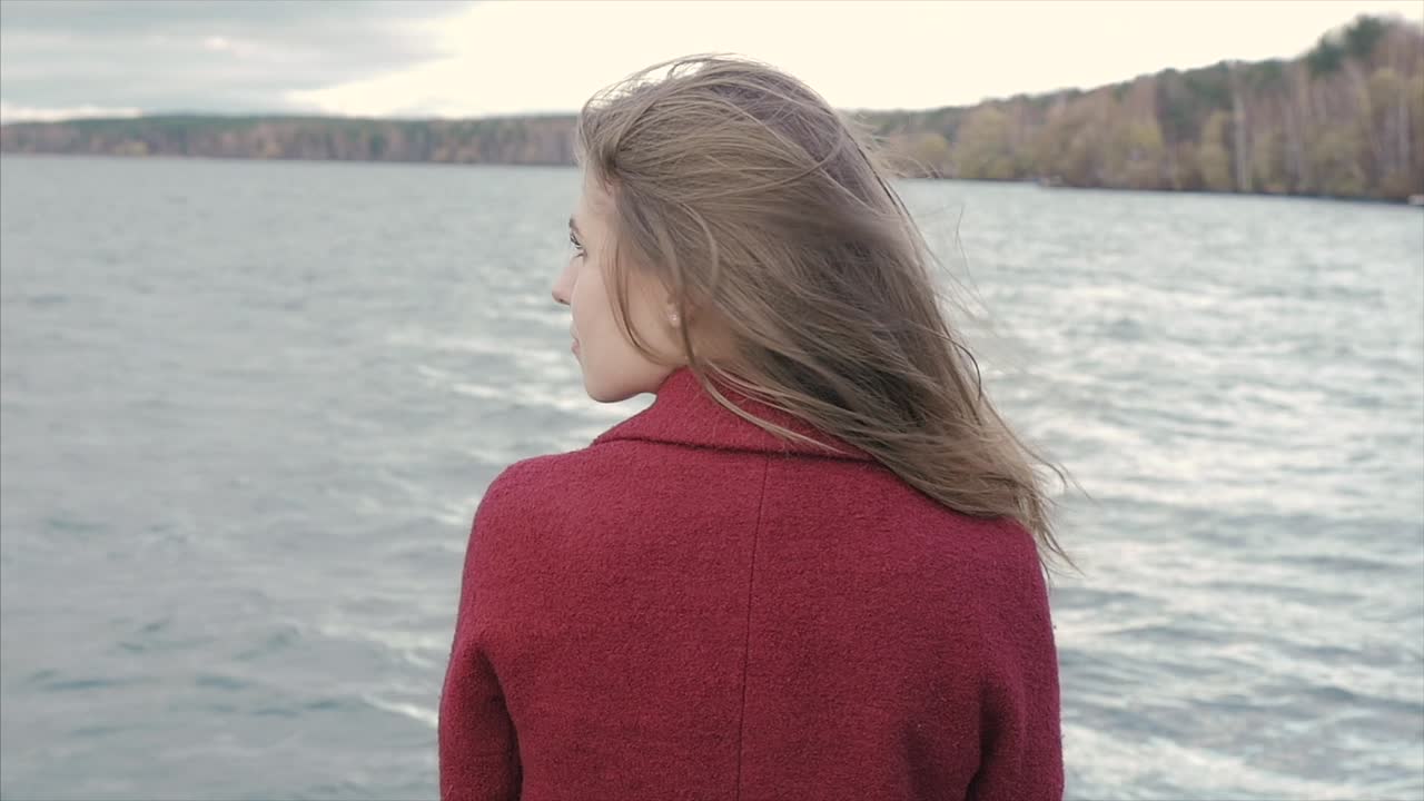Femme au bord du lac en automne