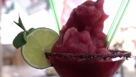 Static-close-up-shot-of-a-berry-cocktail-rimmed-with-spices-and-finished-with-lime