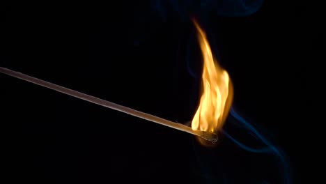 burning match on a black background in slow motion