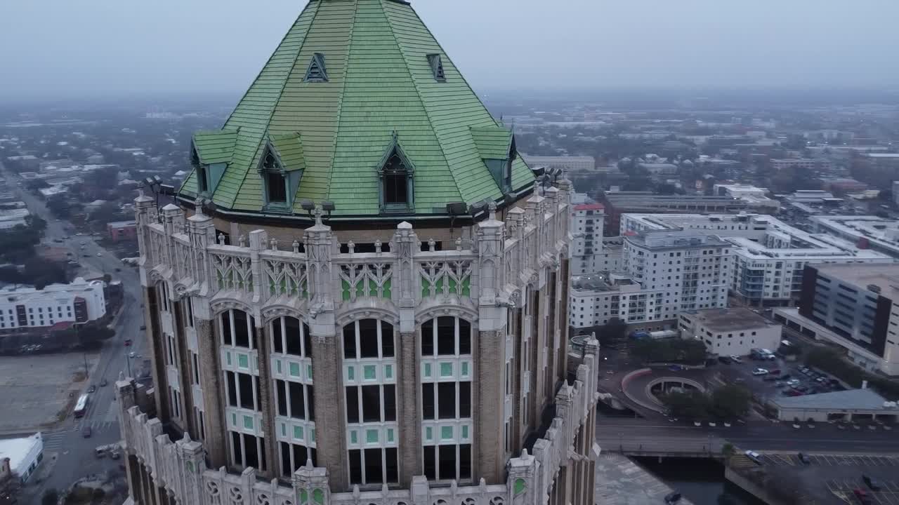 A drone reveals the American flag waving proudly above the city, with skyscrapers and bustling streets below.