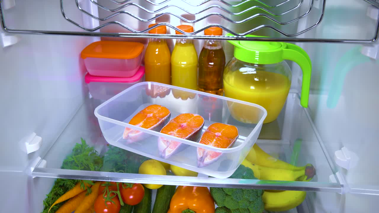 열려 있는 냉장고 에 있는 원시 연어 스테이크