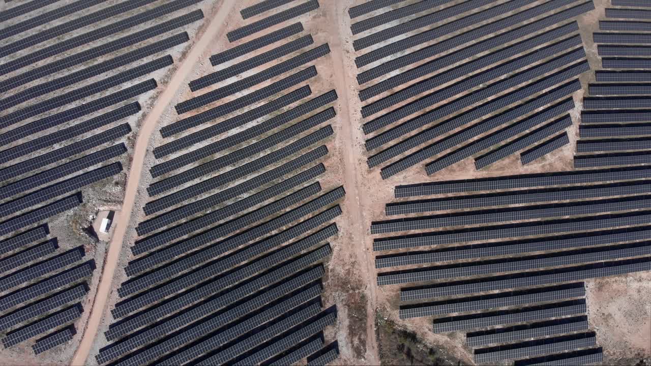 vista dall'alto sull'enorme parco fotovoltaico solare pannelli fila colline soleggiate