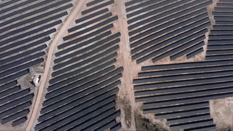 top down view over huge photovoltaic solar power park row panels hills sunny