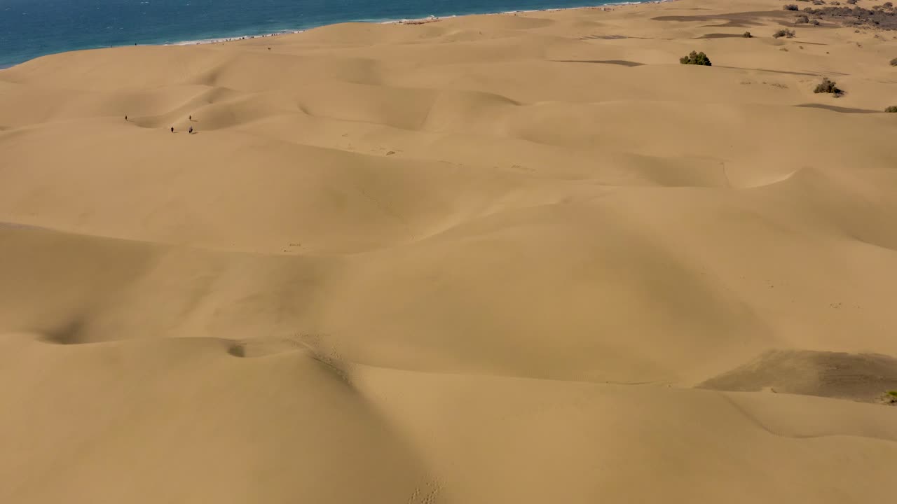 vuelo de drones sobre dunas y desierto con mar y playa, dunas de maspalomas, gran canaria