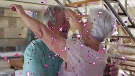 Animation-of-pink-and-purple-confetti-falling-over-happy-caucasian-senior-couple-dancing-at-home