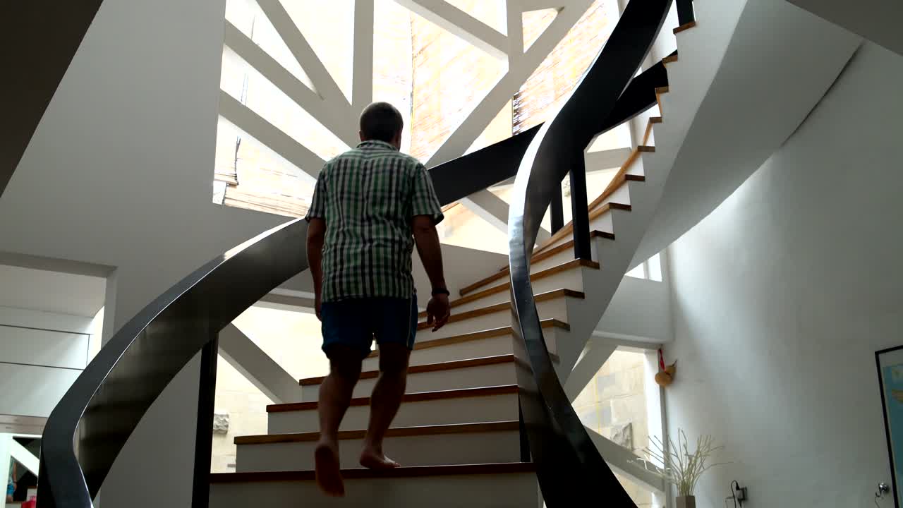 un hombre sube las escaleras al último piso de la casa