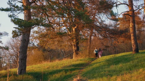young friends running on nature background in autumn. happy couple having a scamper in the forest in the morning.