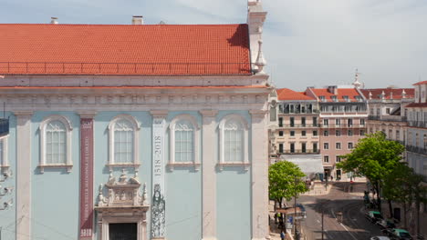 Drone-camera-slowly-rising-over-historic-multi-storey-buildings-in-downtown.-Revealing-city-panorama-with-Tagus-river-in-background.-Lisbon,-capital-of-Portugal.