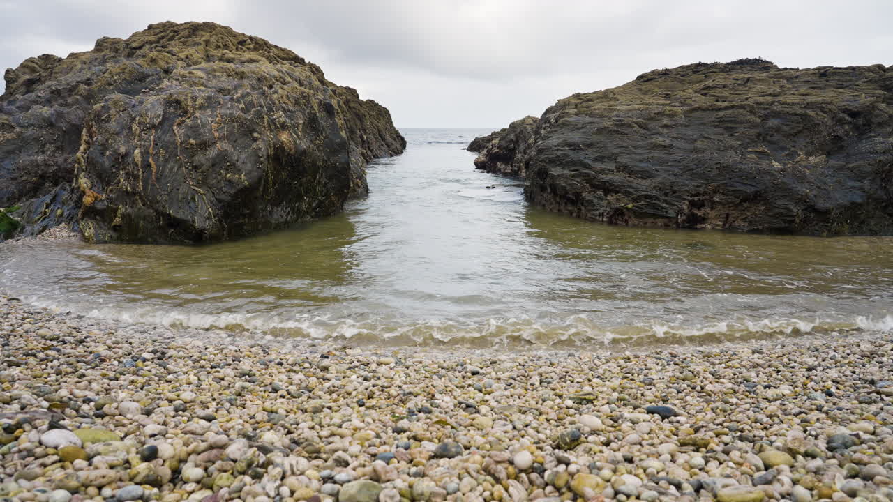 Rocky Coastline with Pebbles and Waves