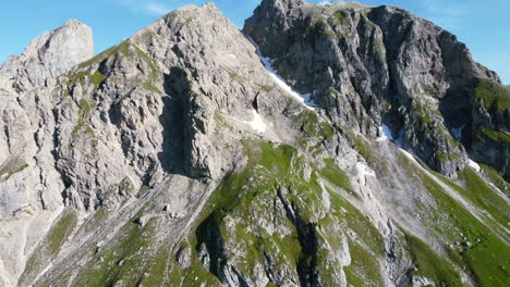 zoom de muñeca aérea de la hermosa cordillera de los dolomitas cubierta de hierba en un día soleado de verano con cielos azules