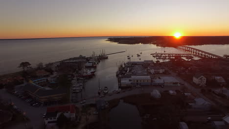 aerial drone flyover of oriental nc harbor and town docks at sunset forward flight with diesel spill facing south