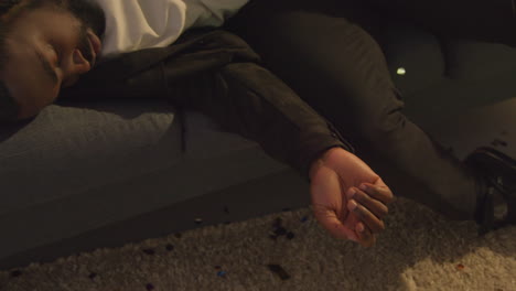 집 파티에서 알코올을 마신 후 소파에서 깨어난 남자가 숙취로 고통 받고 휴대전화에 응답하고 있습니다.