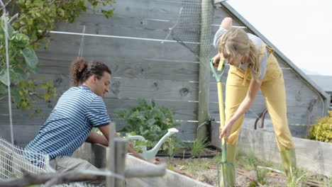 Feliz-Pareja-Diversa-Trabajando-En-El-Jardín-Y-Plantando-Plantas,-Cámara-Lenta