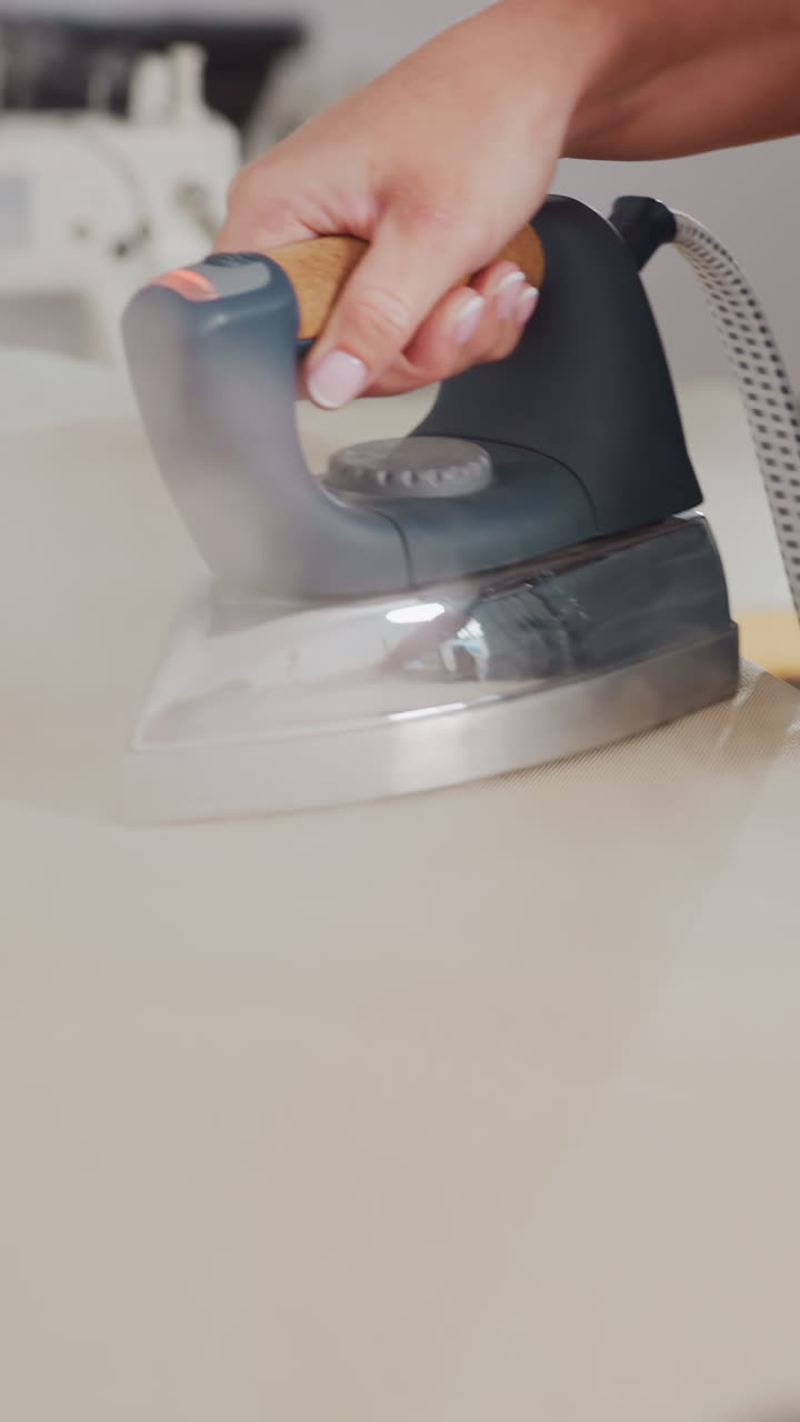 Accurate steam technique on fabric surface, Meticulous steam ironing with firm grip and detailed finish, Precise and dynamic steam pressing on fabric using strong hand grip with textured outcome