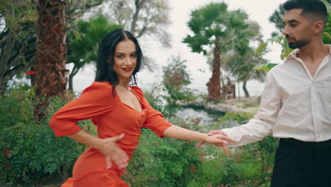 hombre elegante invitando a bailar mujer hermosa en vestido rojo. pareja de bailarines moviéndose