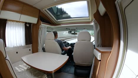 man driving on a road in the camper van