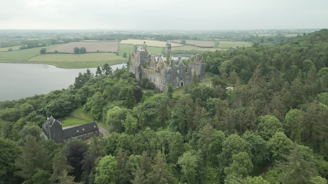 Ancient Castle Ruin Surrounded by Forest Next to a Lake