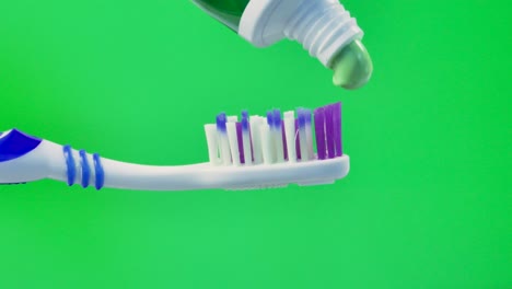cepillo de dientes y pasta de dientes en una pantalla verde. tecla de croma. primer plano.