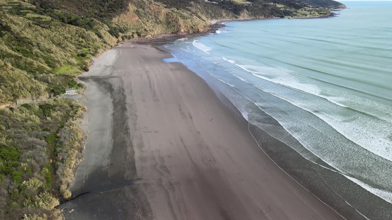 vista aérea sobre la playa de arena negra de raglan en nz