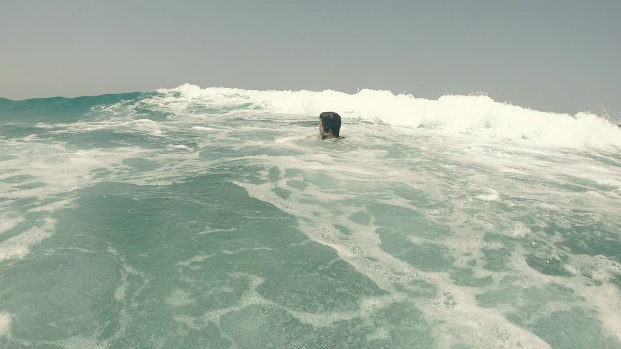 바다의 물결: 여자가 바다에서 부풀어올릴 수 있는 반지 위에서 헤엄친다.