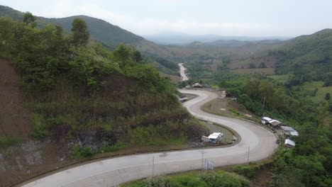 Moving-forward-drone-footage-of-a-twisty-winding-road-on-the-side-of-a-mountain-in-the-Philippines-overlooking-nature