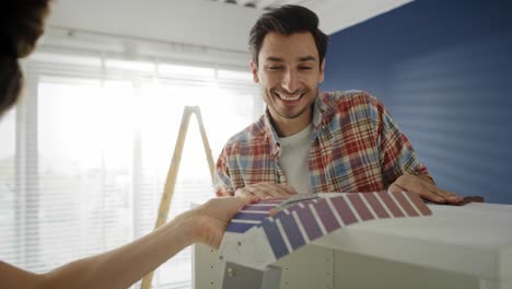 Handheld-video-of-couple-choosing-new-colors-for-the-furniture.