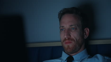 hombre de negocios trabajando en una computadora portátil tarde en la noche, la cara iluminada por el brillo de la pantalla