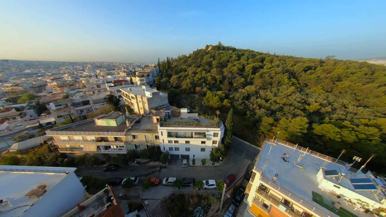 volando un dron fpv por una colina en atenas, grecia, cerca de la acrópolis y el partenón durante el atardecer