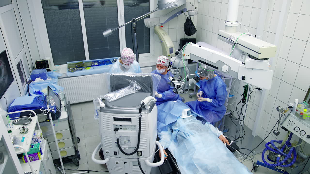 Doctor using microscope during eye surgery. Surgeon looking into the microscope at the eye of patient at the operating room