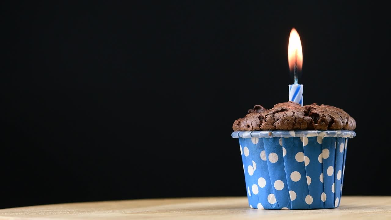 fiesta de pasteles con vela en fondo azul cinemagraph bucle sin costuras.