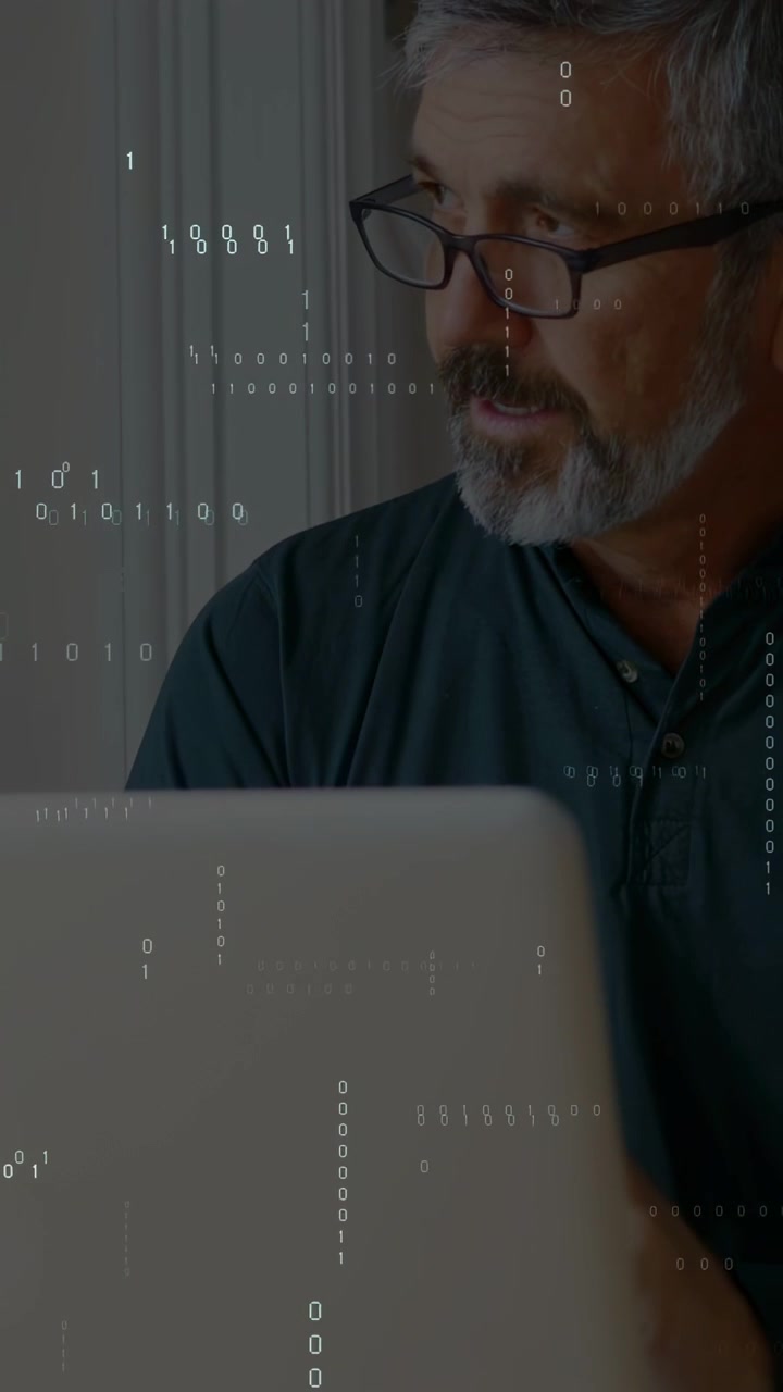 Vertical video: Man reading, fixing specs and typing laptop as binary overlay signaling tech work