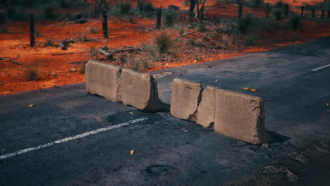 abandoned road with concrete barriers in a desert landscape