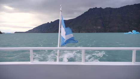 Langsame-Aufnahme-Der-Argentinischen-Flagge-Im-Argentinischen-See,-Die-Sich-Auf-Einem-Boot-Bewegt