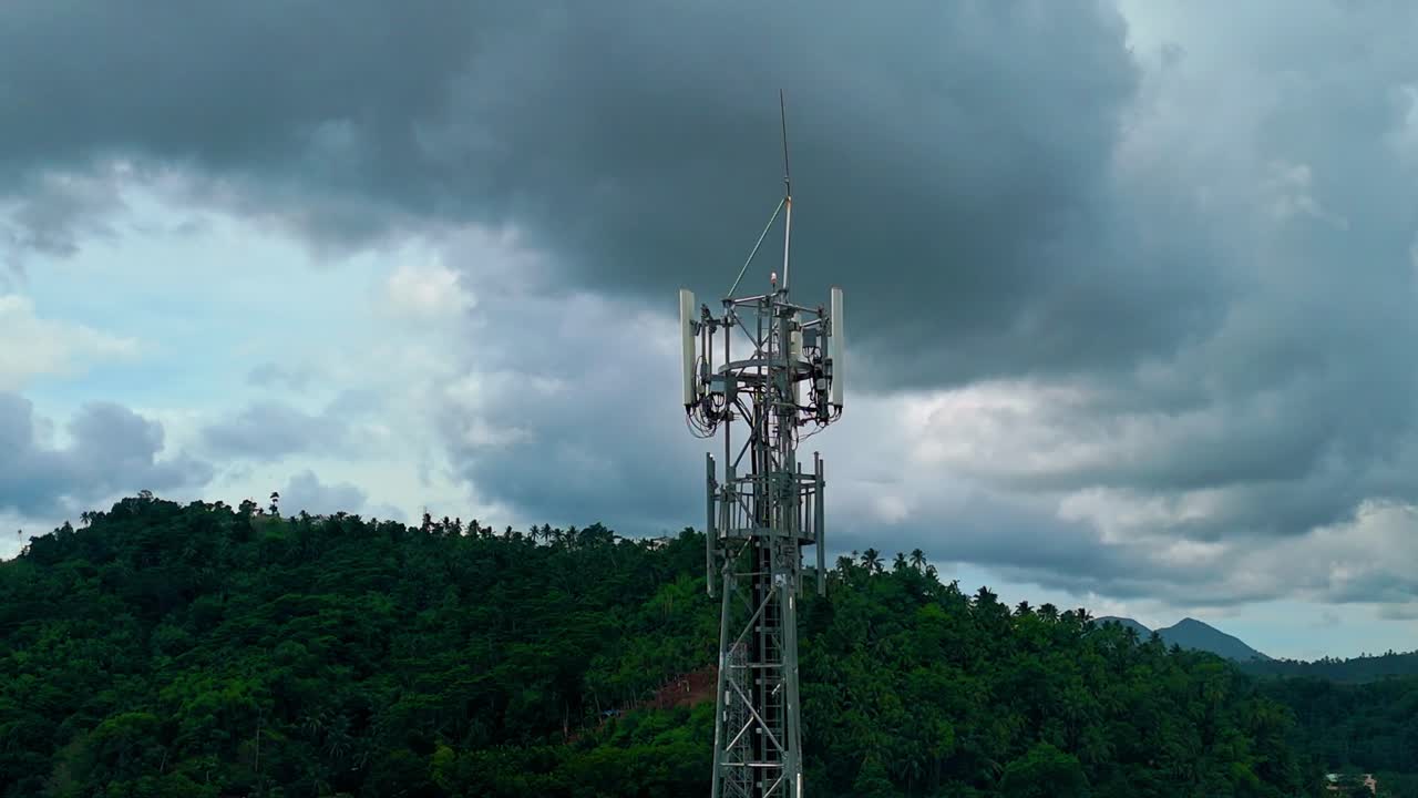 imágenes aéreas de la torre de comunicaciones de teléfonos celulares contra un fondo de cielo oscuro y de mal humor cinematográfico en la jungla filipina