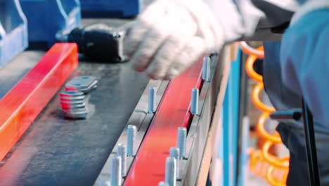 worker making manual assembly of metal components on industrial unit