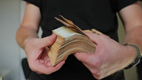 man flips through thick euro cash stack, flaunting wealth in slow motion
