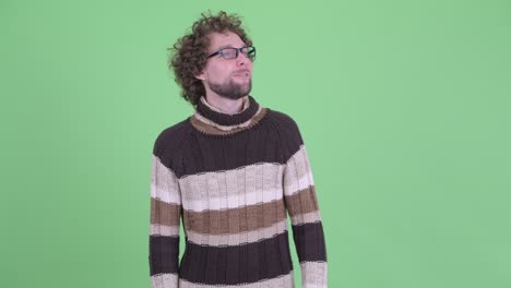 un joven guapo con barba y cabello rizado.