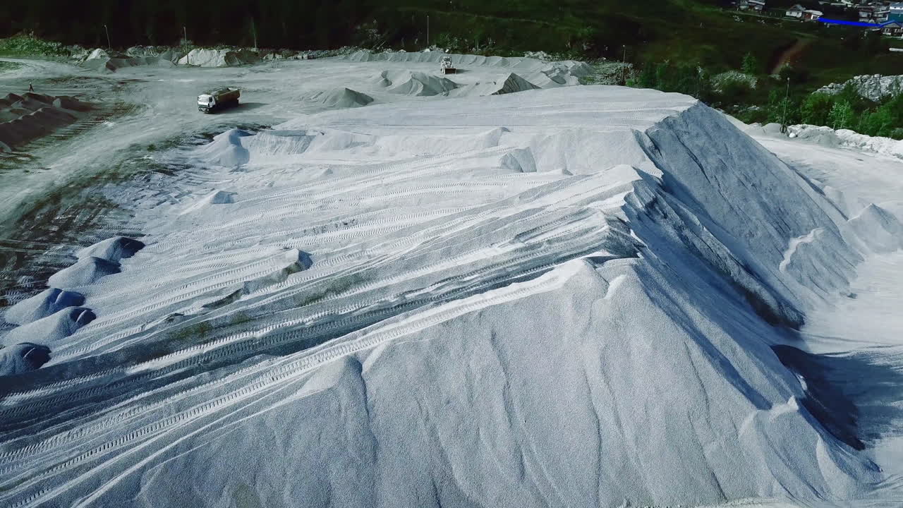 Large Pile of Quarry Materials and Trucks