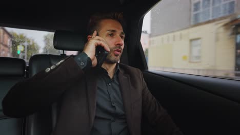 businessman talking on phone in a car