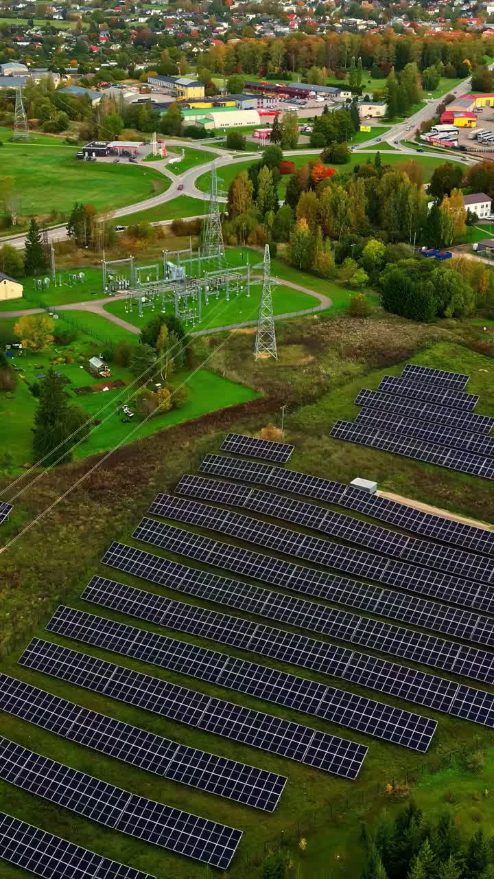 Drone view over solar panels and electric power station with fall trees and houses