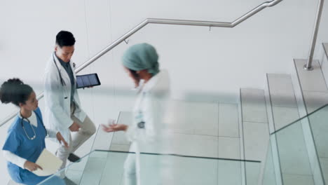 busy, walking and doctors talking in hospital